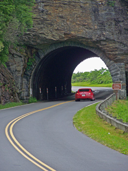 A red sports car drives through Craggy Pinnacle tunnel along the Blue Ridge Parkway.